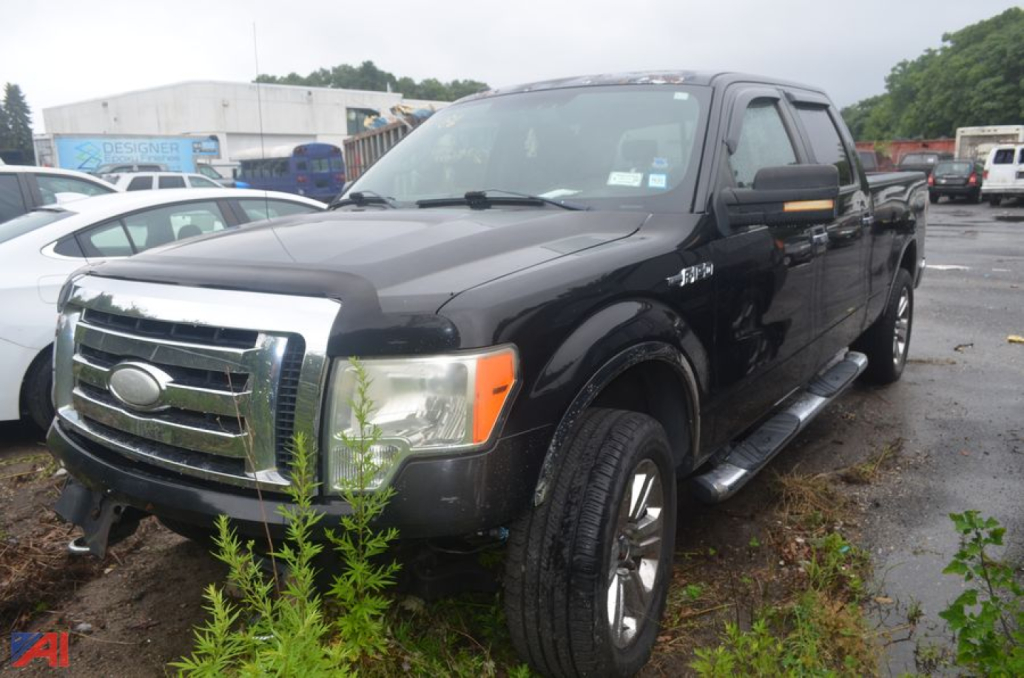 2009 Ford F-150 crew cab pickup truck in black, front left view with chrome grille, running boards, and four-wheel drive badge.
