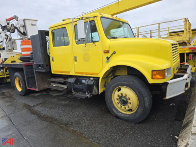 International 4700 flatbed truck in-service shown side view with yellow cab and flatbed equipment.