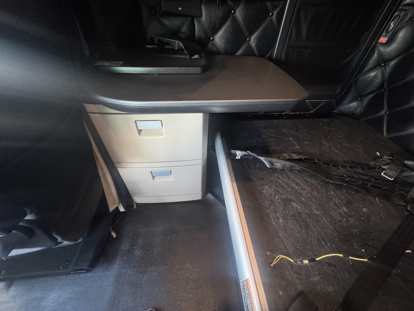 Kenworth T680 truck interior showing captain seat area and sleeper storage with drawers.