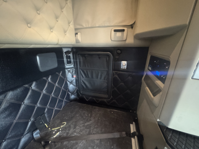 Kenworth T680 interior cabin view with quilted black upholstery and side panel features.