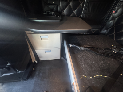 Kenworth T680 truck interior showing captain seat area and sleeper storage with drawers.