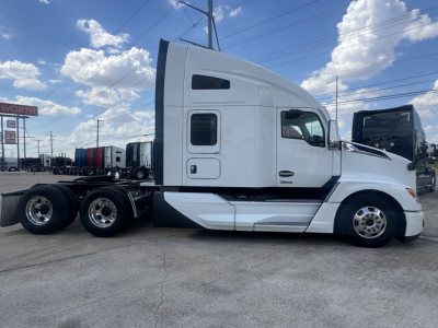 Kenworth T680 tractor side view showing sleeper cab and wheel chassis with 6 wheels in a used truck lot.