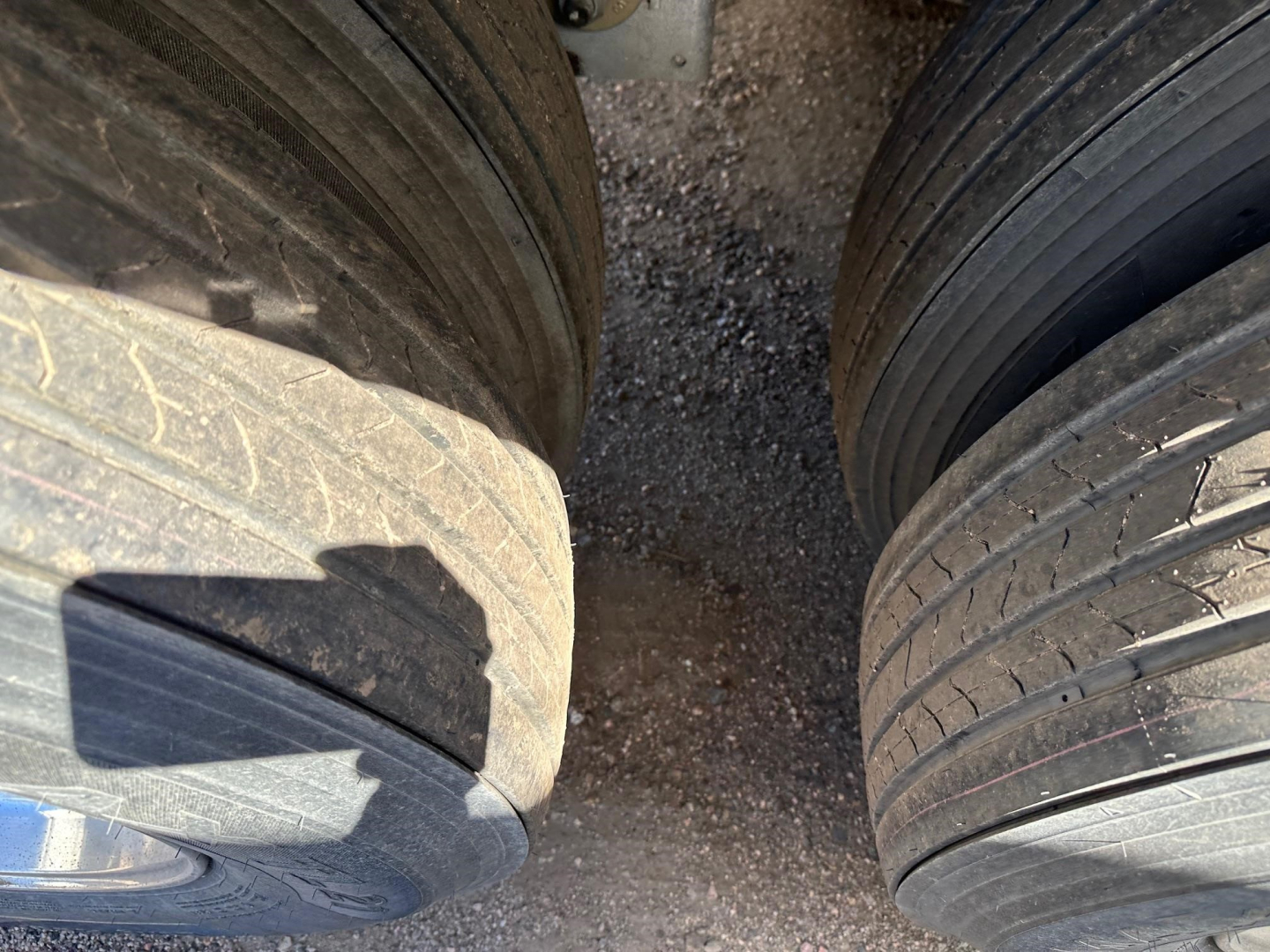 Stoughton air-ride grain trailer tires and wheels close-up view showing dual axles and tread patterns.