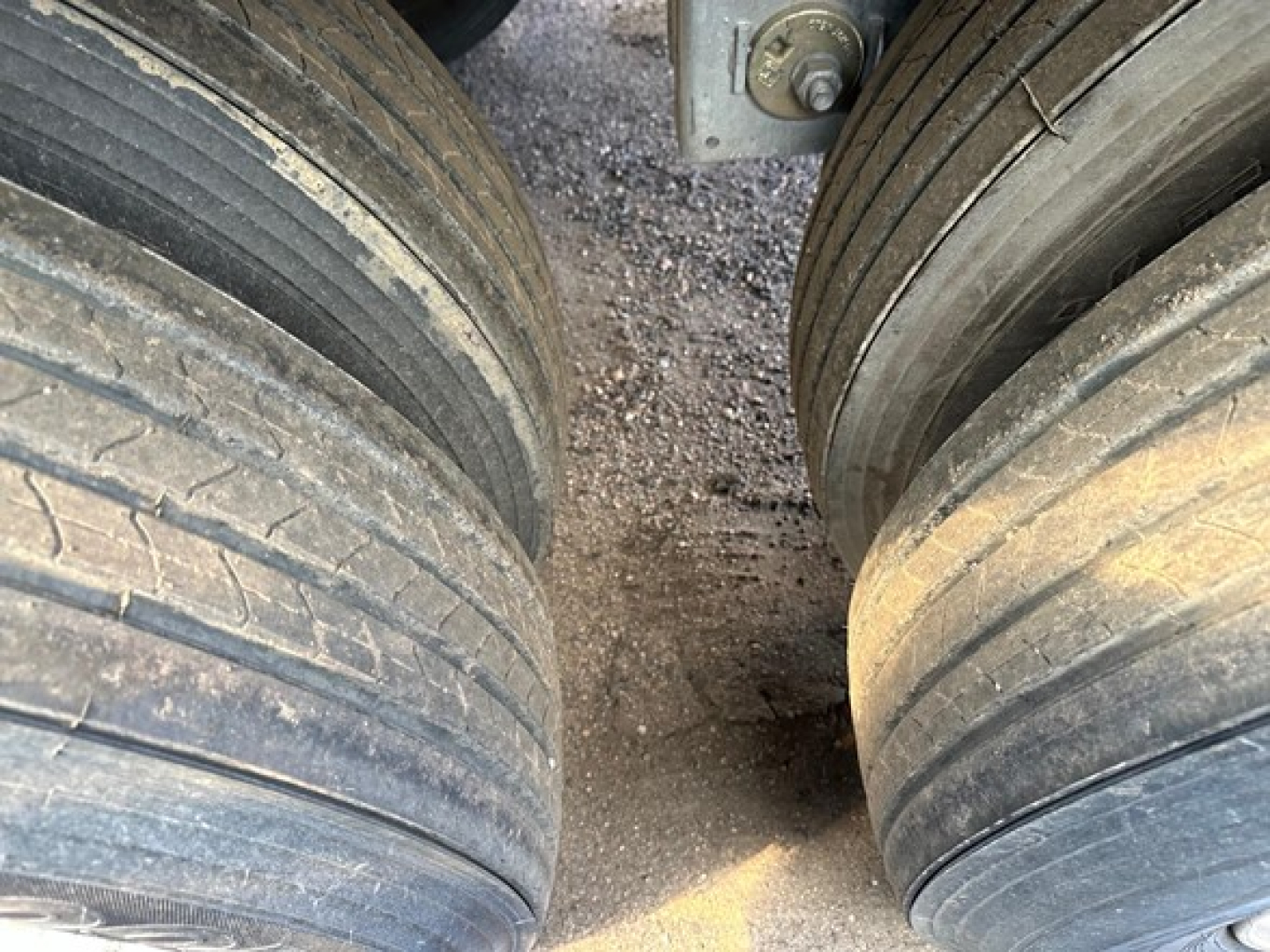 Trailer wheels and suspension showing dual rear tires of a Stoughton air ride grain trailer undercarriage view.