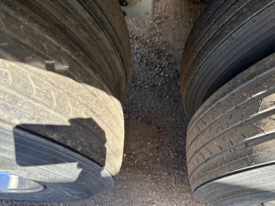 Stoughton air ride grain trailer wheel area showing dual tires and tread with gravel surface.