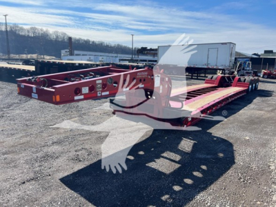 Lowboy trailer in red with two paired decks and a gooseneck section, showing flat trailer frames and suspension, Fontaine logo faintly visible; clear sky and yard in background.