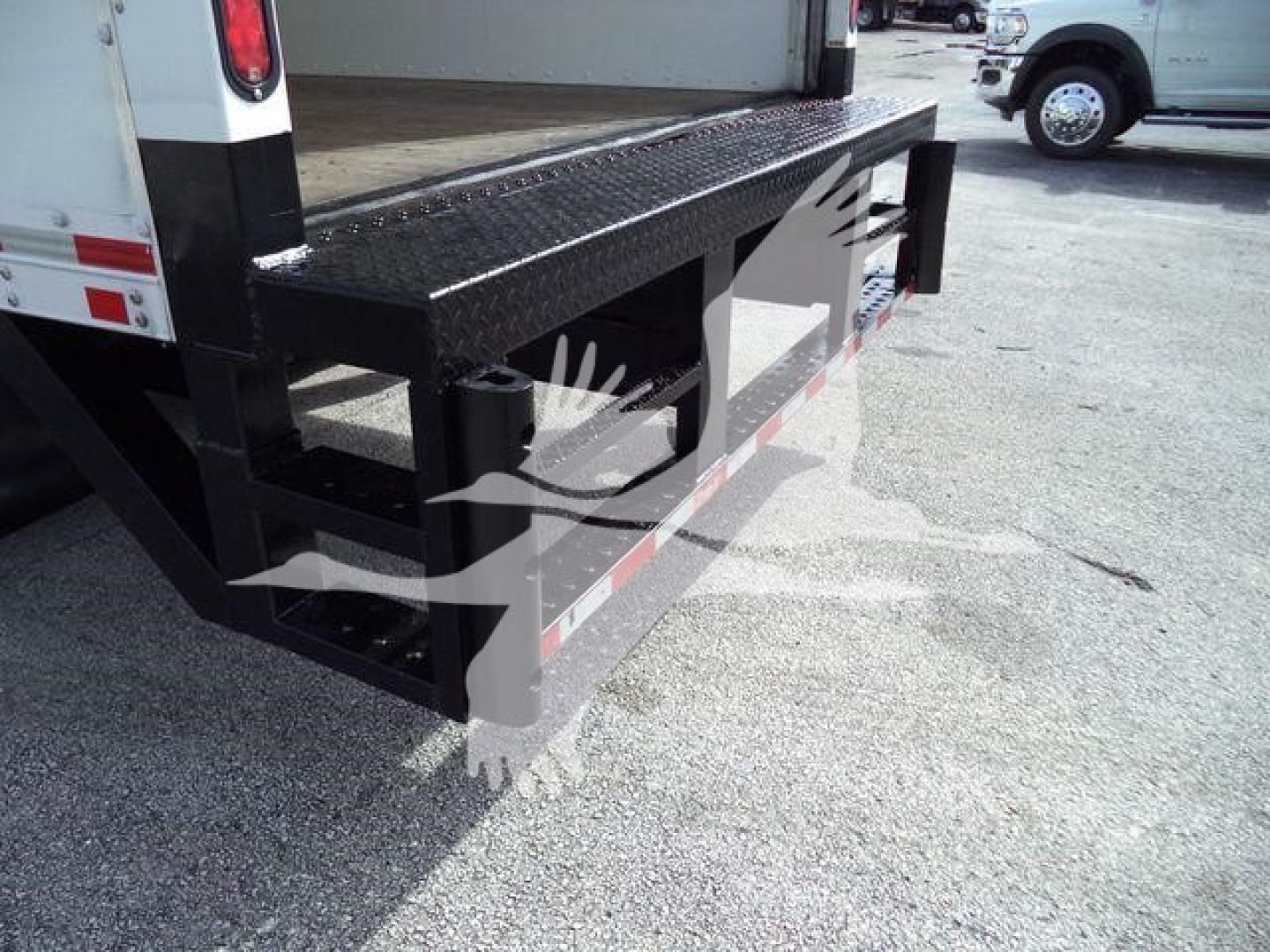 Isuzu NPR HD truck with a black steel step/ bumper and platform, side view showing the rear step and bumper assembly.