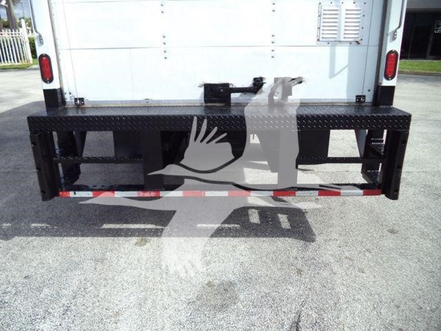 Isuzu NPR-HD truck rear with black diamondplate steel bumper/steps, tailgate area, and reflective safety striping.