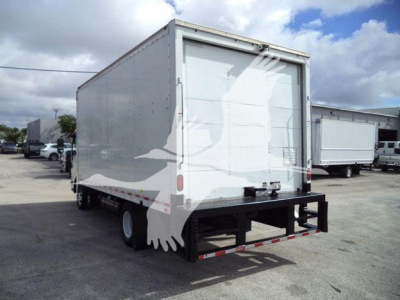 Box truck rear view showing cargo box and bumper with taillights and reflective tape.