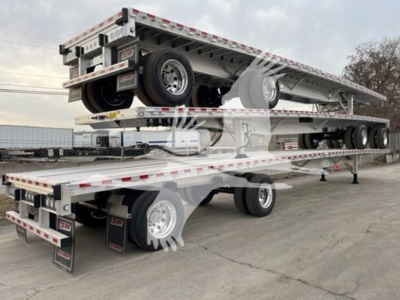 Reitnouer CK-100 flatbed trailer stacked on trailer with multiple axles and wheels visible.