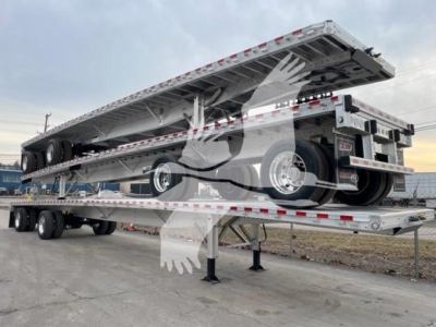Flatbed trailer with a reitnouer CK-100 style car carrier in raised position, dual-axle trailer with metal decking and reflective tape.