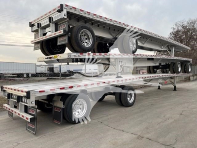 Flatbed trailer stacked on a multi-axle trailer showing tandem axles and wheel assemblies with reflective tape and Rinjouer branding.