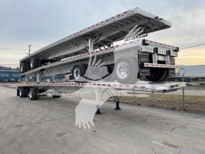 Outline of a flatbed trailer with a raised bed on a multi-axle trailer, rear wheels, and reflective strips; appears to be a Reitnouer CK-100 type trailer.