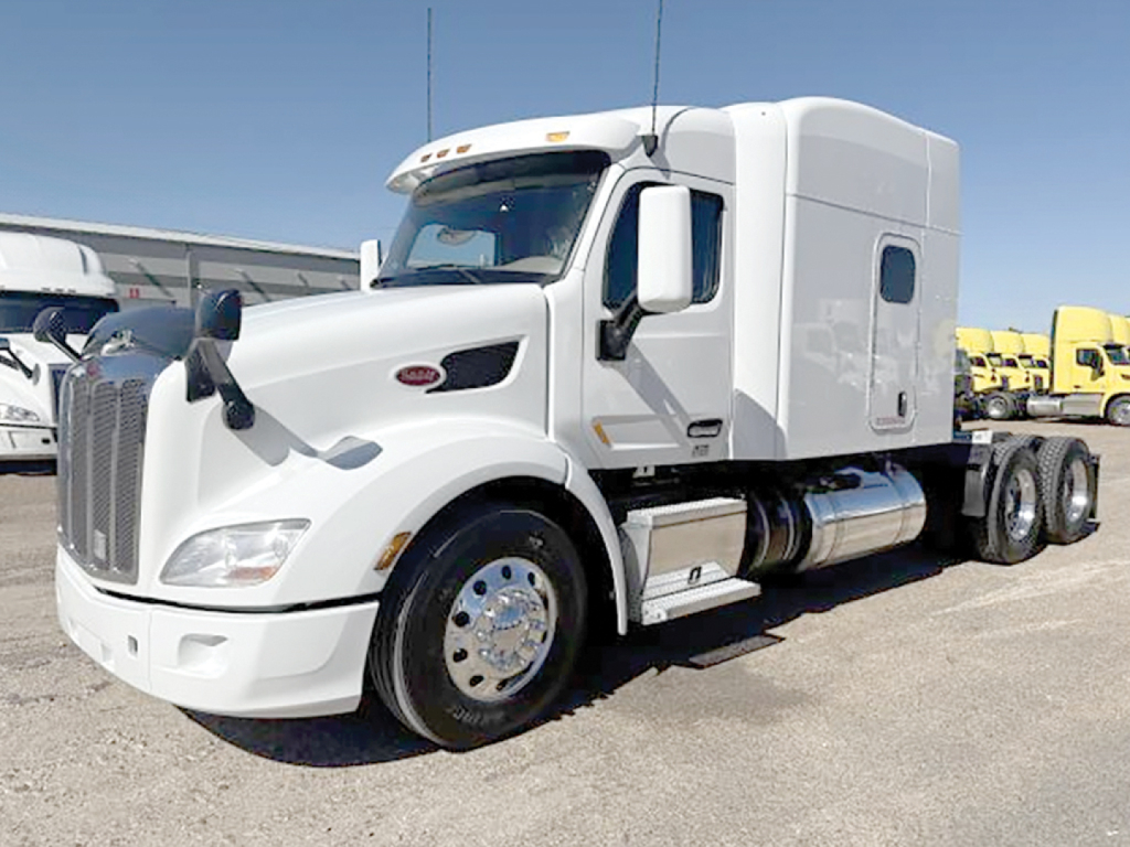 Peterbilt 579 UltraCab tractor in white front-left view with chrome wheels and fuel tanks.