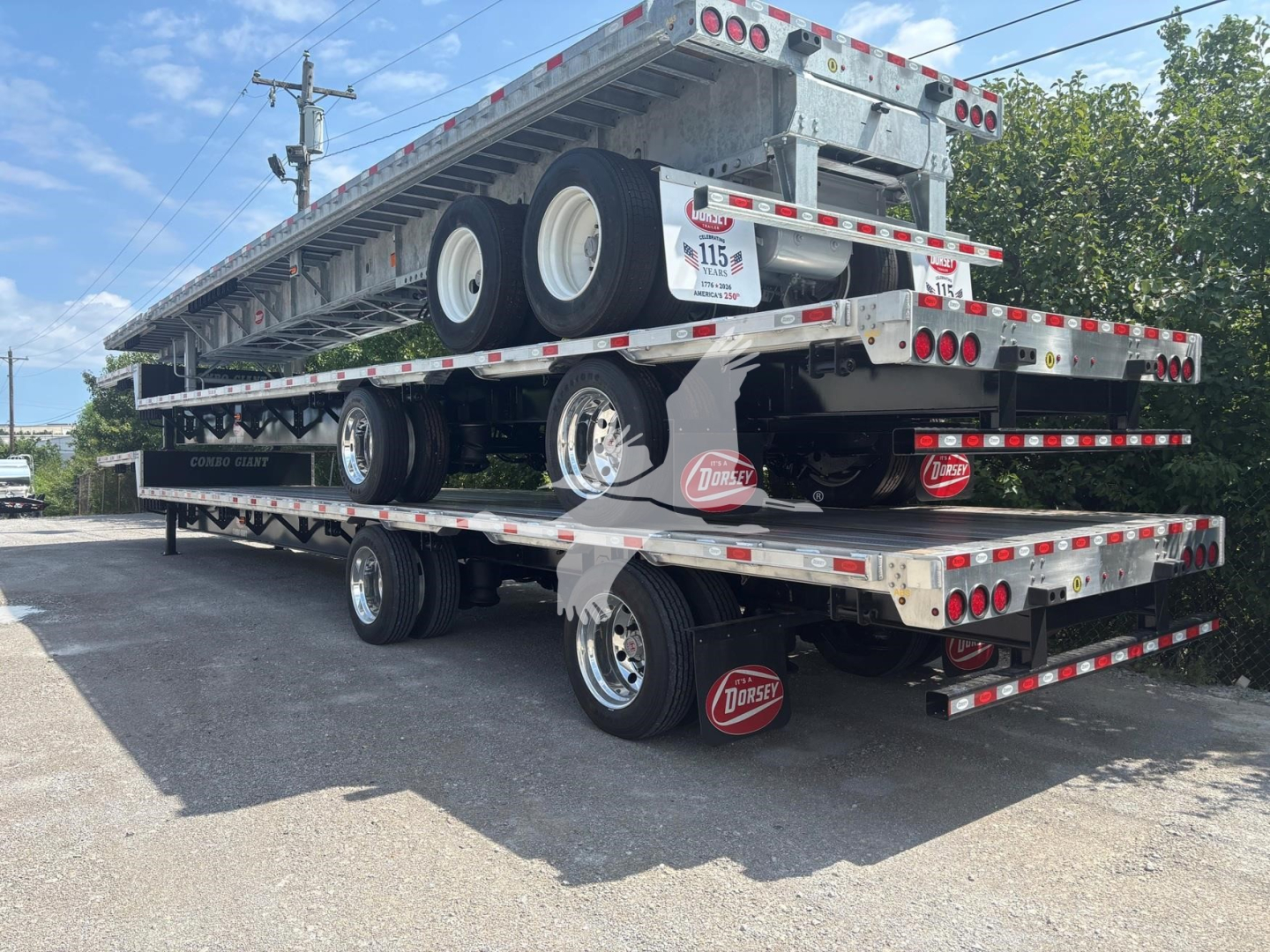 Trailer stack showing a Dorsey Combo Drop flatbed trailer with stacked decks and dual wheels, DOT reflectors, and Dorsey hub covers.