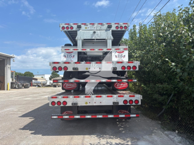 Trailer rear view showing multiple tandem axles and reflective striping on a Dorsey combo drop deck trailer.