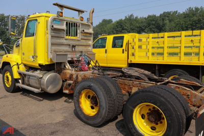 Truck cab and chassis showing bright yellow Western Star tractor with dual rear wheels and exposed frame.