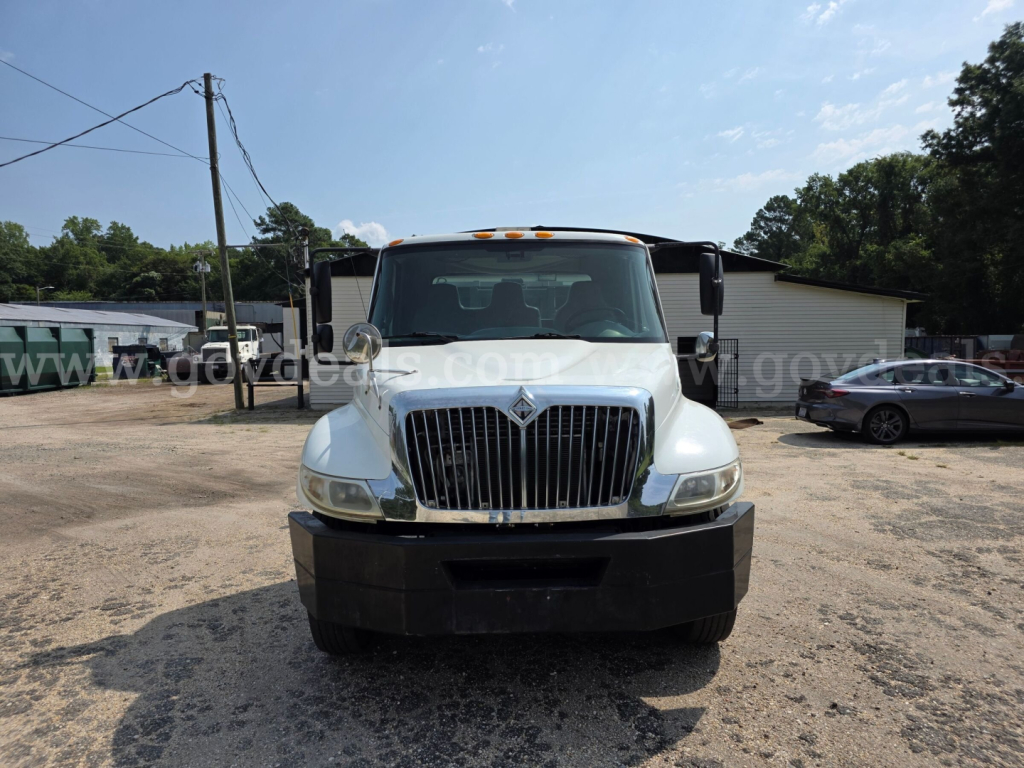 Front view of a white 2005 International 4300 DT466 truck with grille and bumper, parked in a lot.