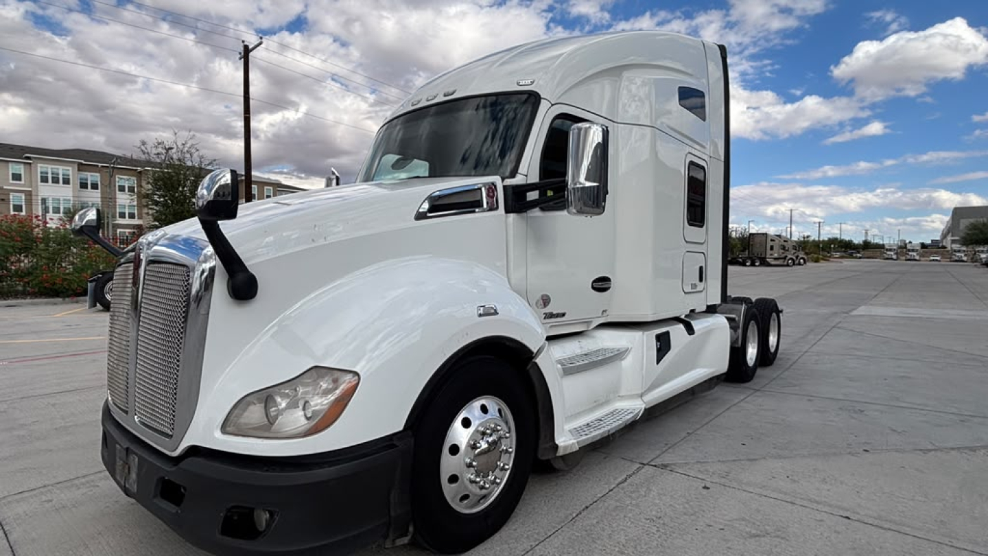 Kenworth T680 tractor unit in white, front-left view with sleeper cab and chrome grille. No visible text other than truck design features.