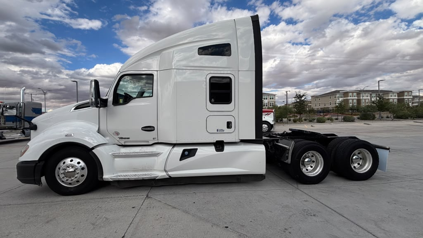 Kenworth T680 tractor side profile showing sleeper cab and dual rear axles with chrome wheels.