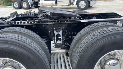 Vehicle chassis of a 2022 Kenworth T680 showing dual rear wheels and undercarriage components; image focuses on suspension/axle area with tires and frame.