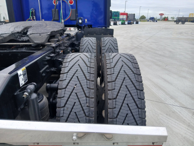 Peterbilt 579 tractor rear dual tires and chassis showing undercarriage components and air hoses.