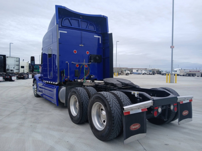 Peterbilt 579 tractor rear view showing tandem axle and fifth wheel with blue cab. Visible text includes Peterbilt mud flaps and chassis components. VIN board not visible; generic truck rear.