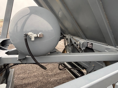 Ranco LW24464 trailer component showing a round grey air tank with hose and metal brackets in a dump trailer chassis.