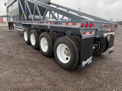 Trailer underside and wheels showing multiple axles and tires with Ranco LW24464 model name on a dump trailer.