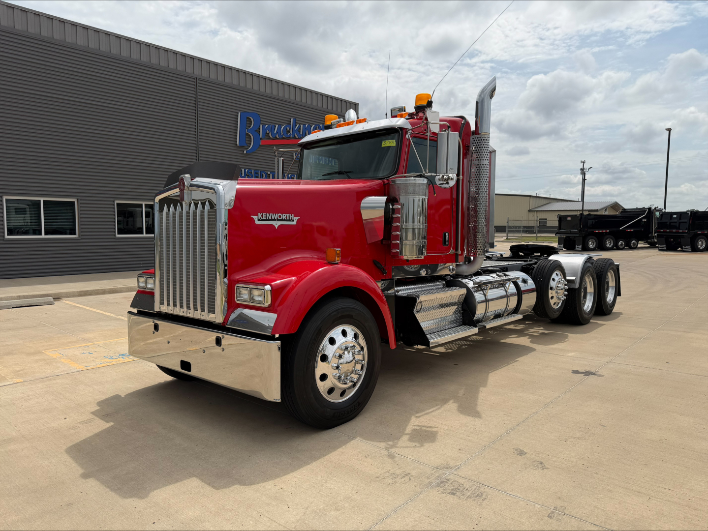 Kenworth W900L conventional daycab truck in red with chrome exhaust stacks and dual rear axles.