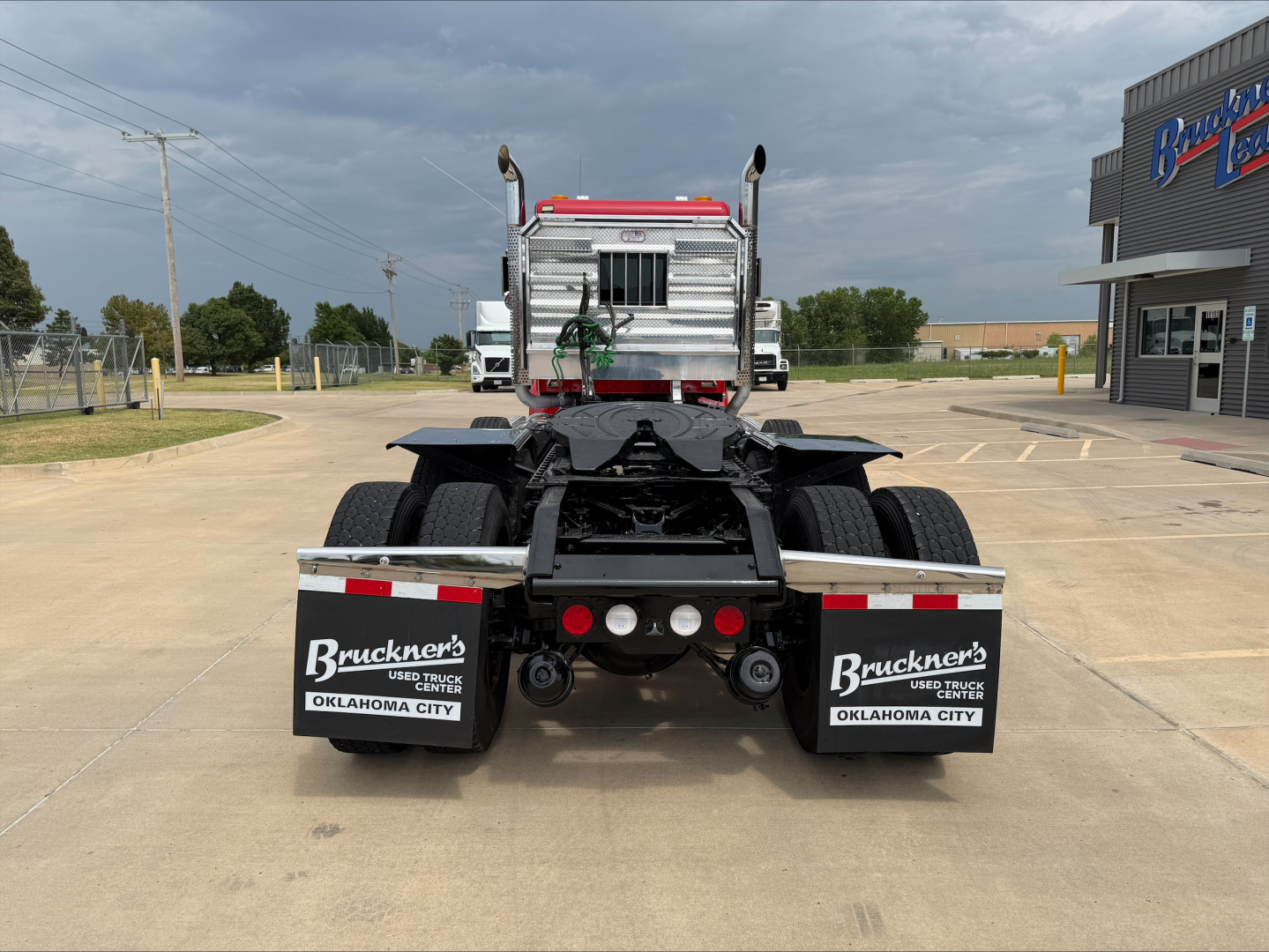 Rear view of a 2022 Kenworth W900L truck tractor showing dual rear axles and mud flaps with Buckner's Oklahoma City branding.