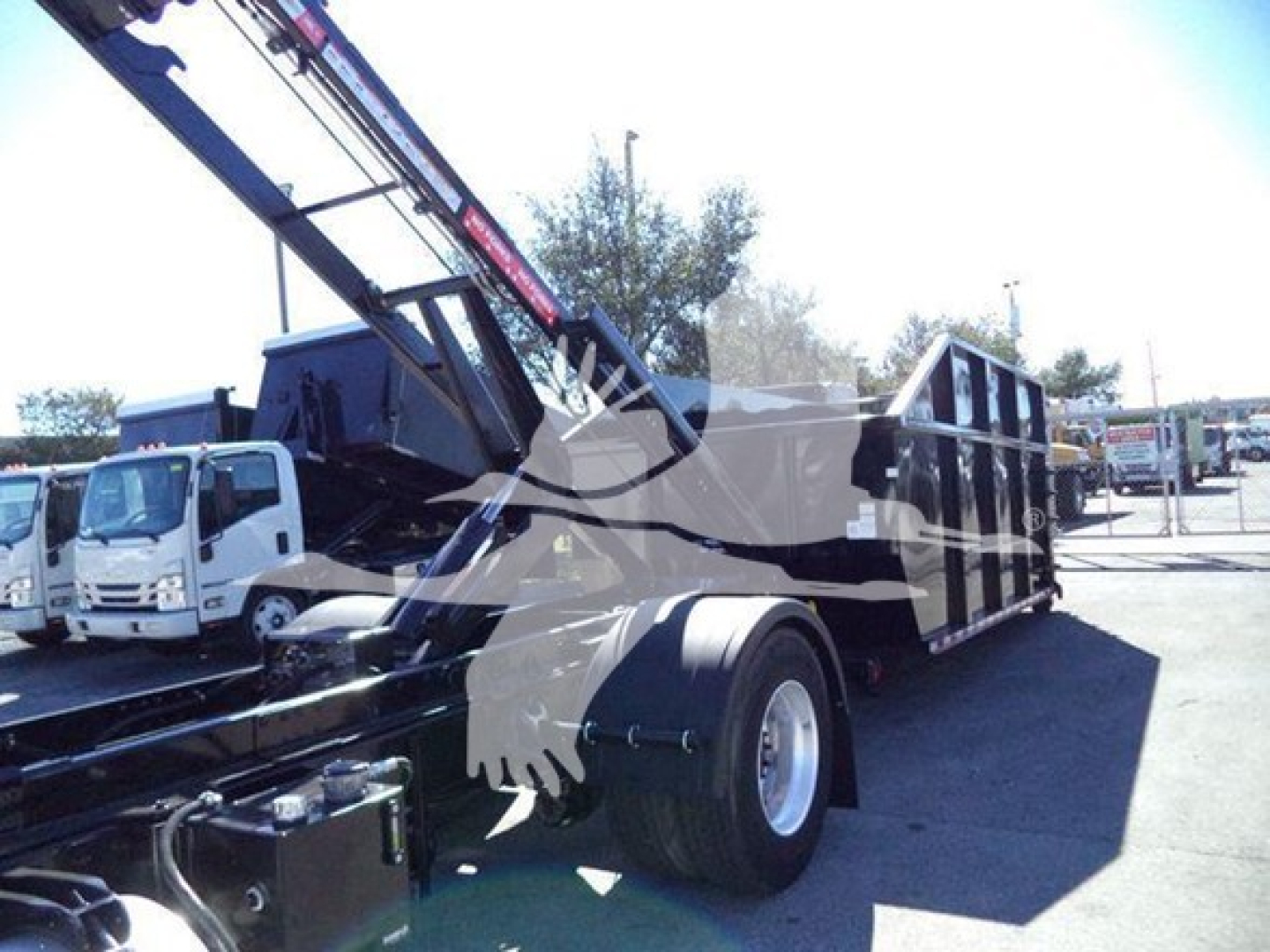Peterbilt 337 roll-off truck chassis showing crane arm and truck bed with hydraulic components.