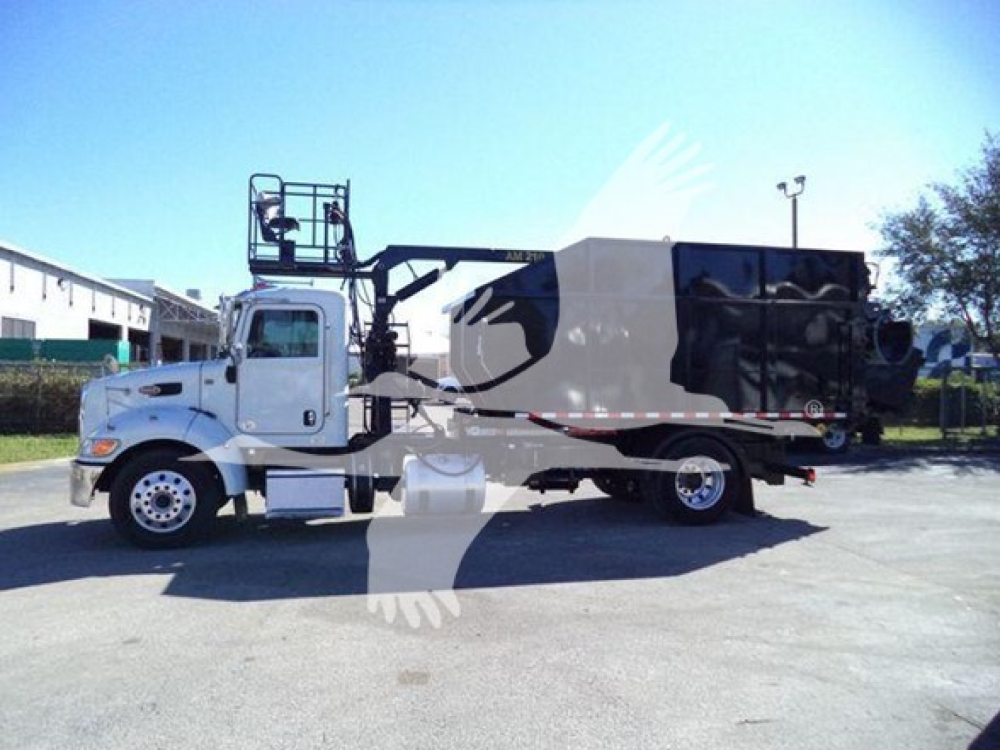 2020 Peterbilt 337 roll-off truck in side view with cab and dumping body visible.