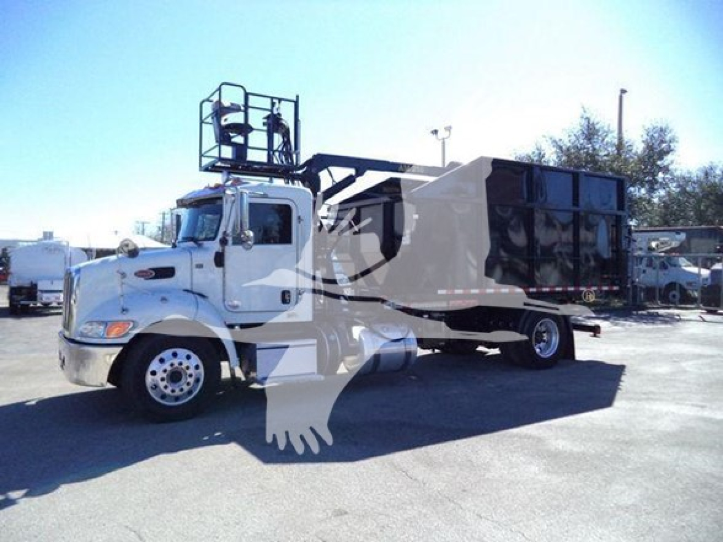 Peterbilt 337 roll-off truck in-service showing cab and dump bed with hydraulic system and rear dumpster container.