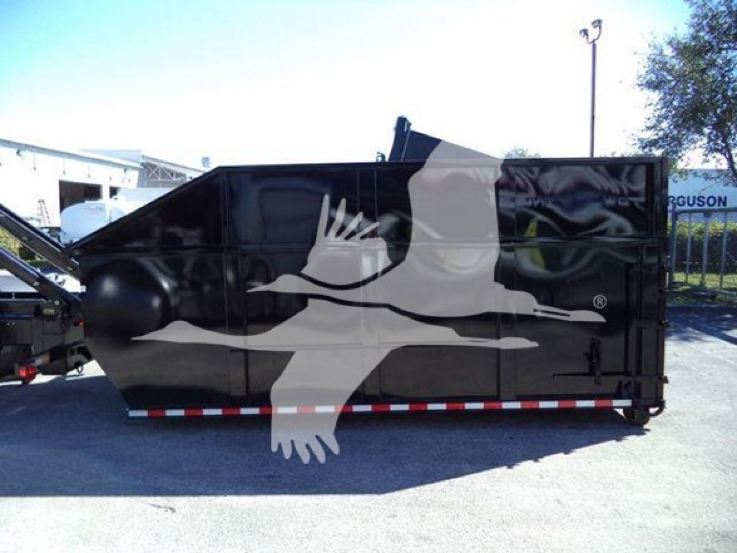 Peterbilt 337 roll-off truck side view showing black exterior with large white graphic of a bird in flight.