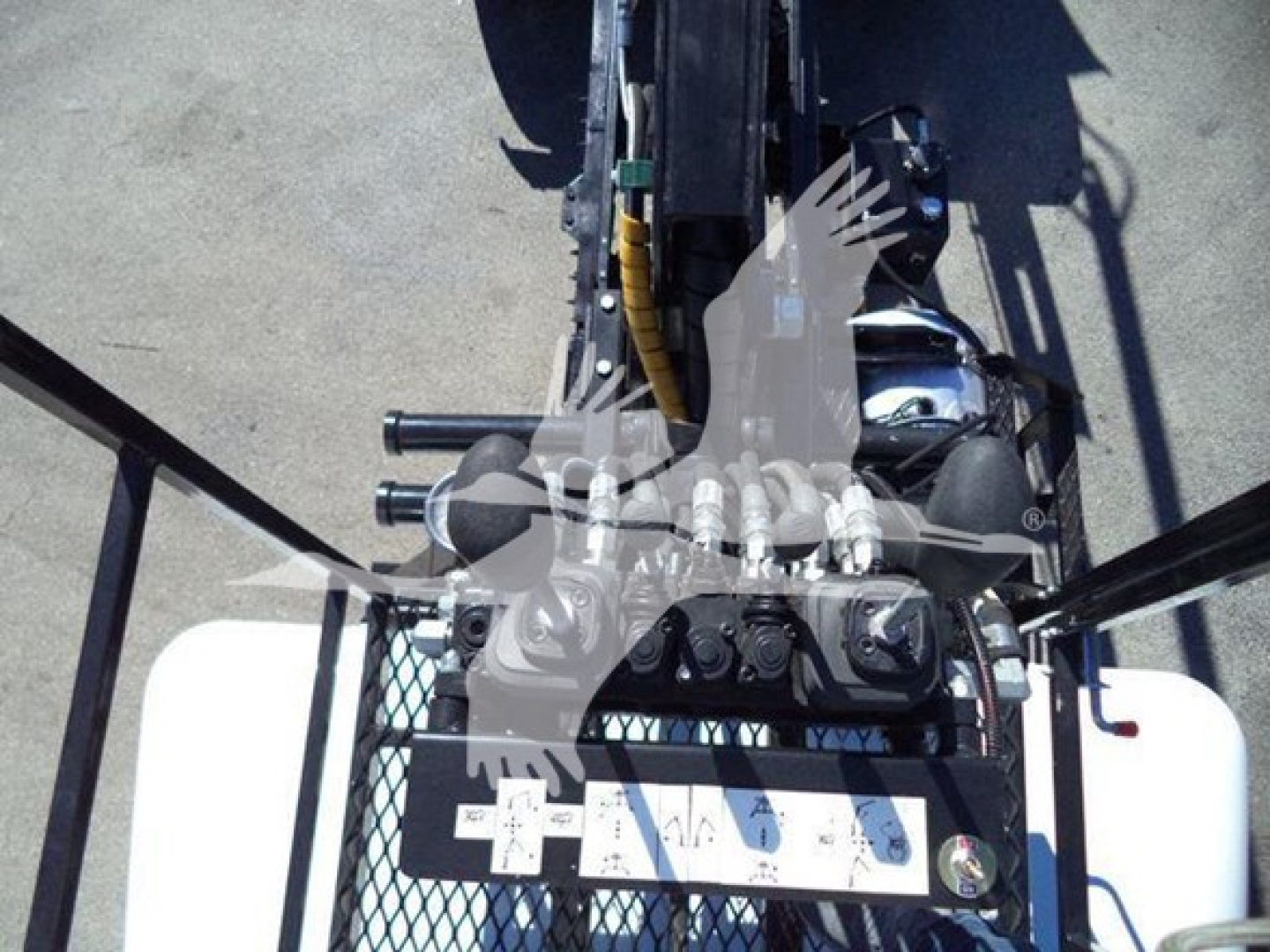 Peterbilt 337 roll-off truck rear view showing controls and frame with hydraulic lines and operator platform.