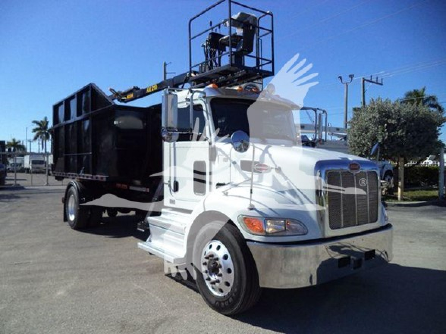 Peterbilt 337 rolloff truck showing cab and dump bed with lifting mechanism and elevated platform.