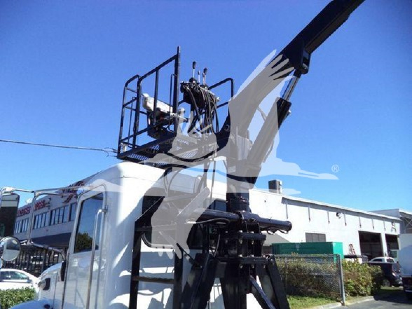 Peterbilt 337 rolloff truck cab and hydraulic lifting arm visible