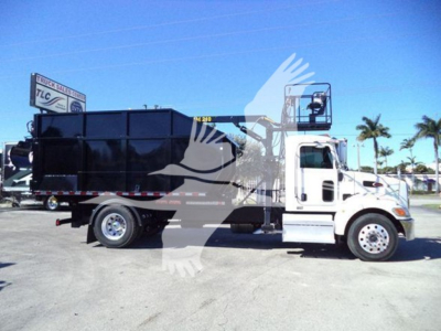 Peterbilt 337 dump truck side view showing roll-off bed with black container and white cab.