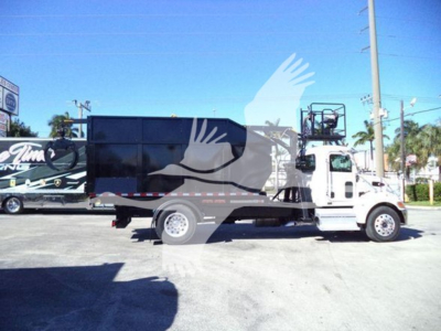 Peterbilt 337 roll-off truck in side view showing cargo bed and cab with white chassis