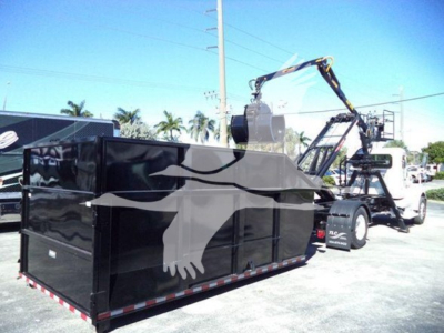 Peterbilt 337 roll-off truck with a large black dump container and crane in background, visible text not legible on container; VIN and stock not on image itself.