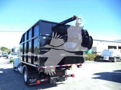 Peterbilt 337 roll-off truck rear view showing hydraulic hoist and dump body with winch and safety lights.
