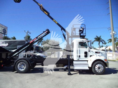 Peterbilt 337 rolloff truck side view with crane arm extended, white cab, black chassis, VIN 2NP2HM6X6LM718973 visible on listing.