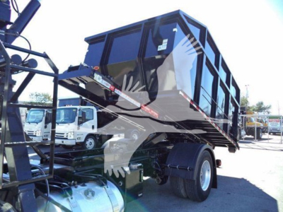 Peterbilt 337 roll-off truck bed with tilted cab and rear dual wheels, black body with reflective stripes.