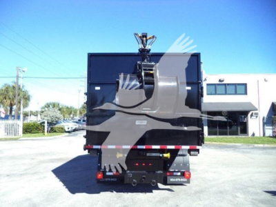 Peterbilt 337 rolloff truck rear view showing hydraulic lift and black cargo box with reflective taillights.