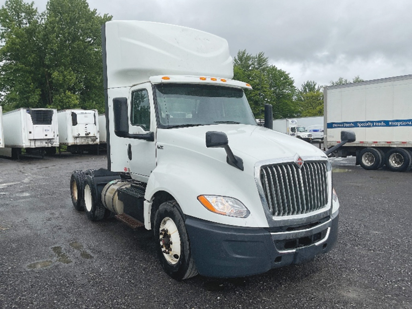 Truck cab showing International LT625 in-service day cab with white exterior, grille, and dual rear axles. Visible VIN 3HSDZAPR8KN045027 and stock number 551482.