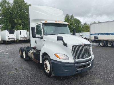 Truck cab showing International LT625 in-service day cab with white exterior, grille, and dual rear axles. Visible VIN 3HSDZAPR8KN045027 and stock number 551482.