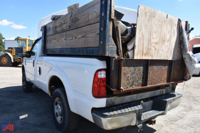 Ford F-250 Super Duty single rear wheel pickup with wooden bed sides and rusty metal tailgate, rear three-quarter view
