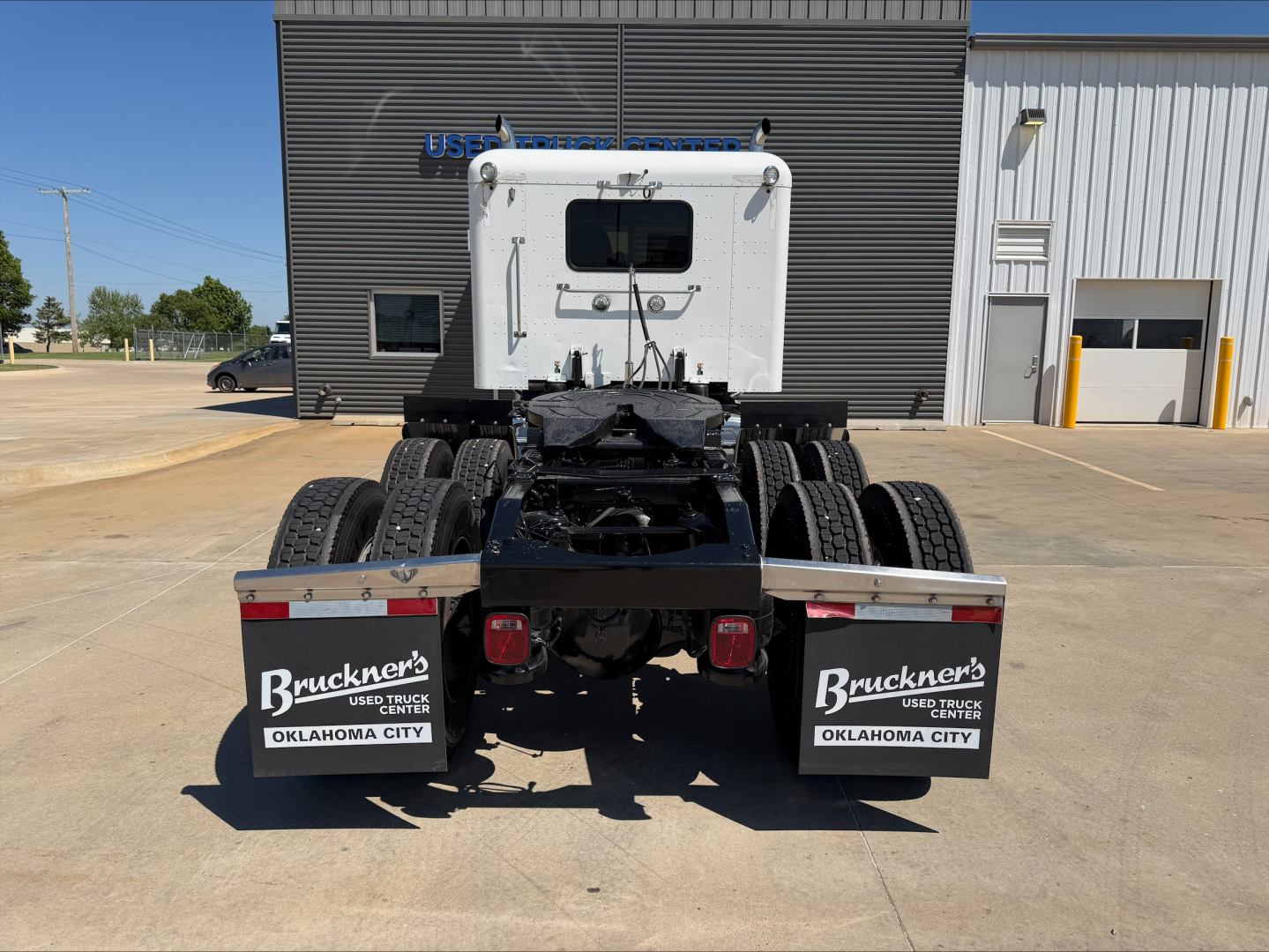 Peterbilt 389 tractor cab rear view showing fifth wheel, dual rear axles, and mud flaps with Bruckner’s Oklahoma City branding.