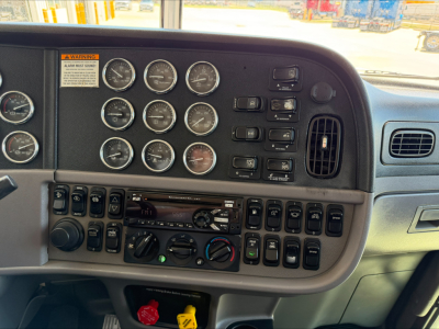 Peterbilt 389 dash panel showing multiple gauges and switches in a sleeper truck cab (front view).